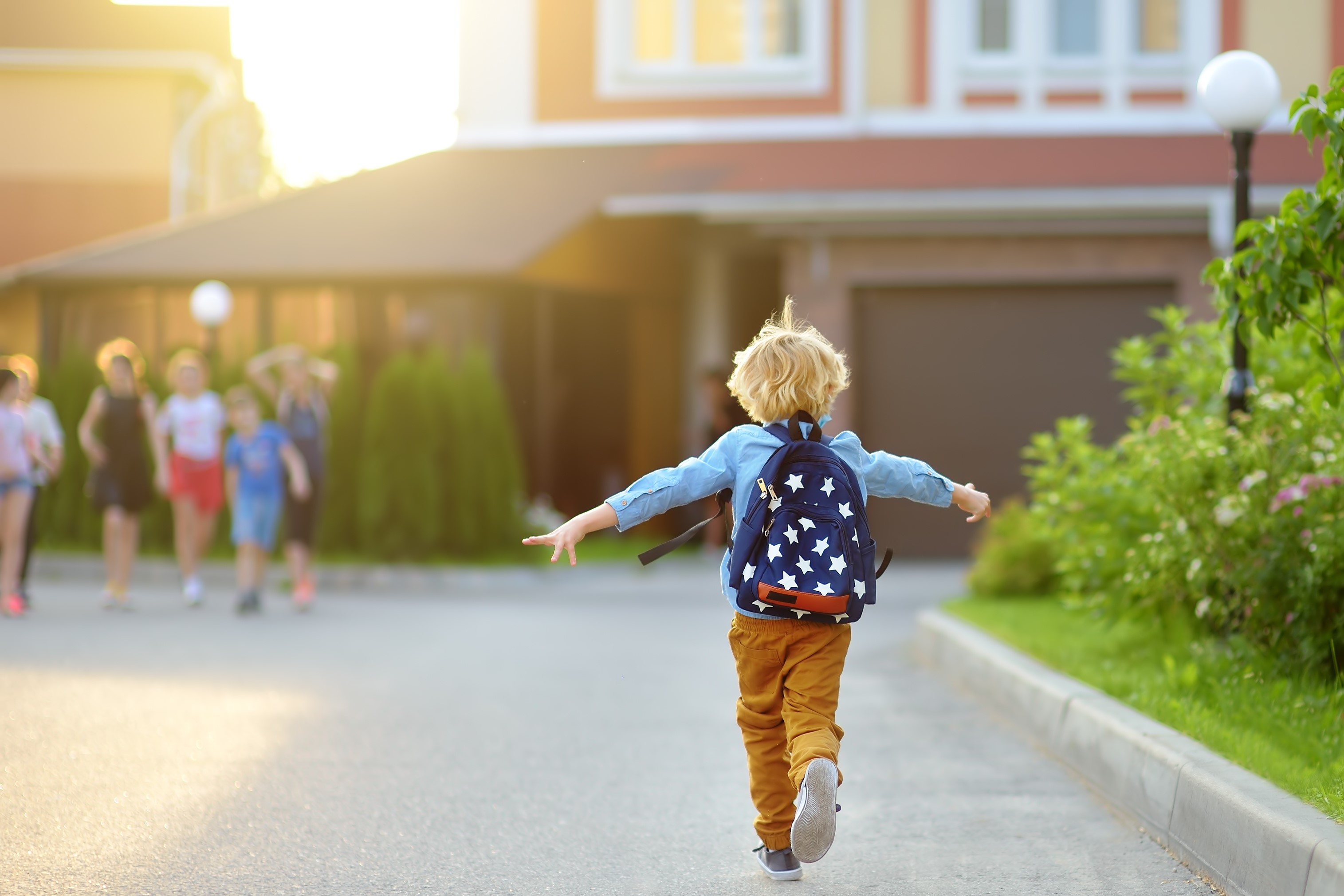 Children greeting one another outside in a warm community setting